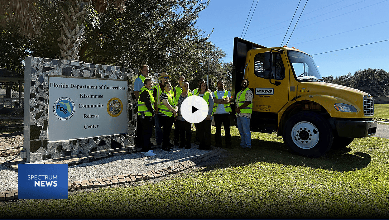 Group of inmates posing next to truck